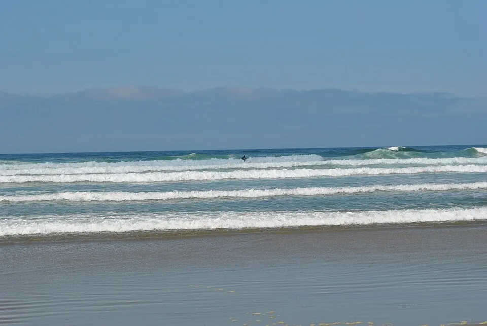 Surfer moving through water at Wickaninnish Beach
